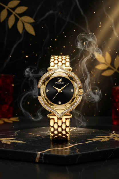 Gold Swarovski watch on a gray cushion with a branded box in the background